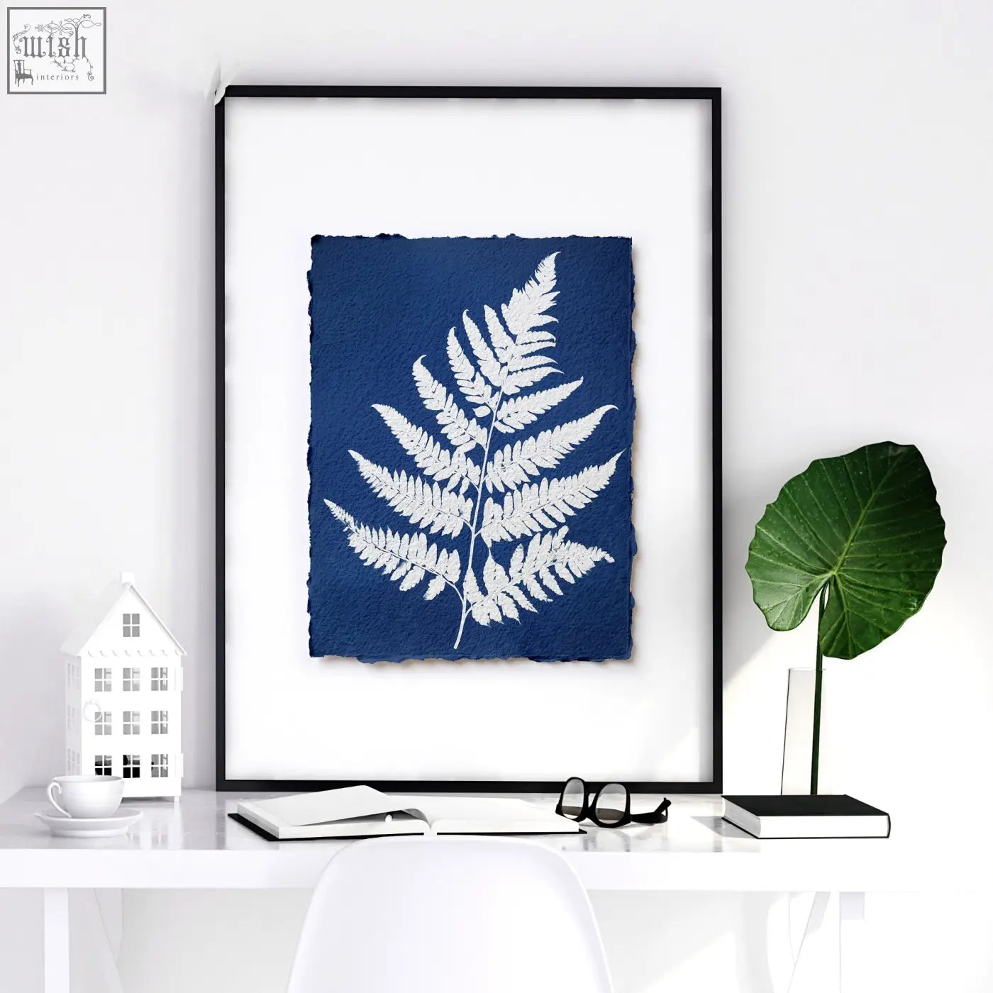 A framed blue and white floral art wall print featuring a detailed fern silhouette on textured paper in indigo tones
