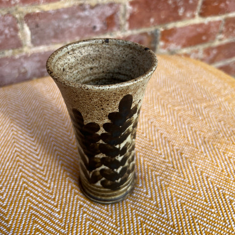 A rustic floral ceramic vase with speckled beige glaze and dark brown leaf patterns for home decor