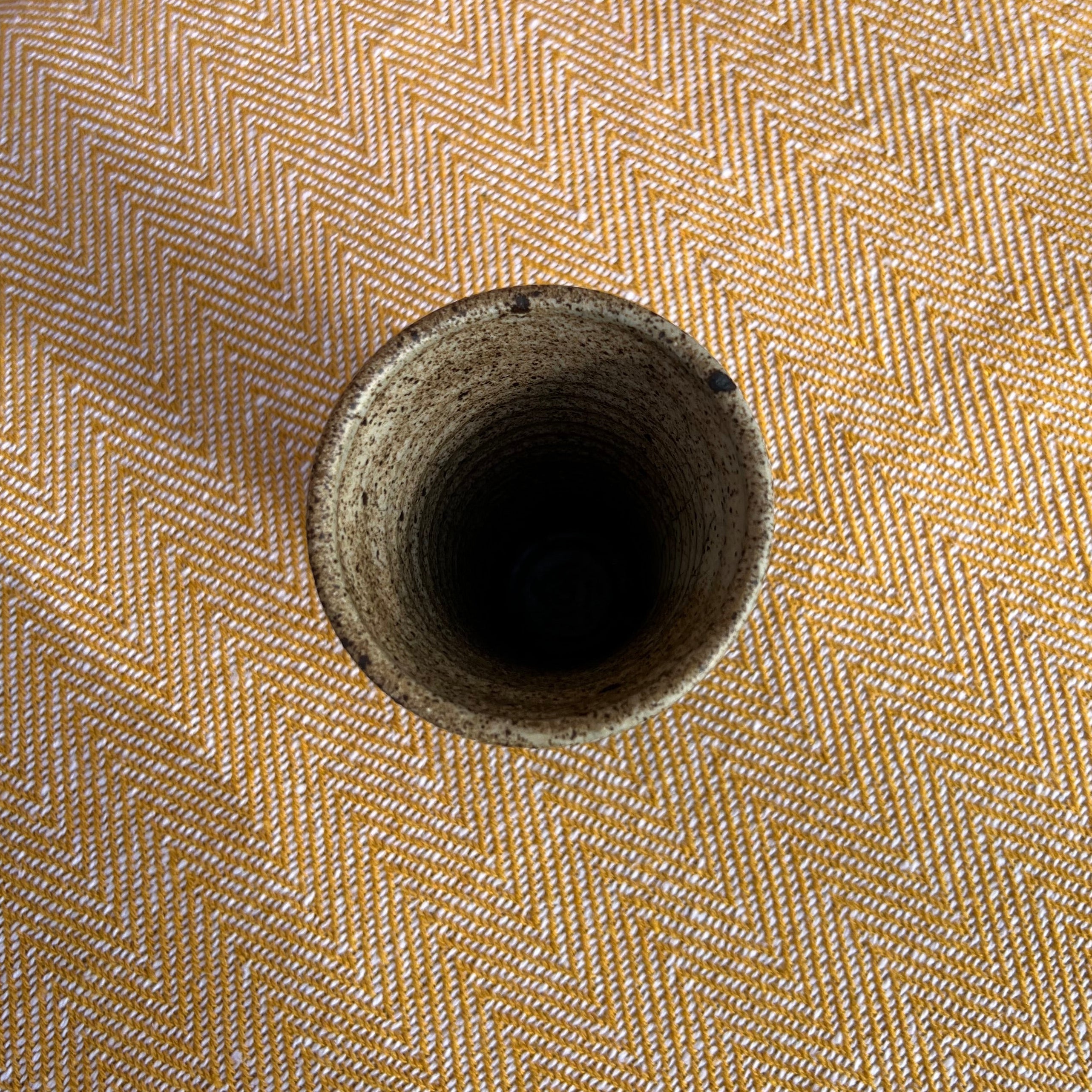 A rustic floral ceramic vase with a speckled matte finish and slightly uneven rim perfect for flowers