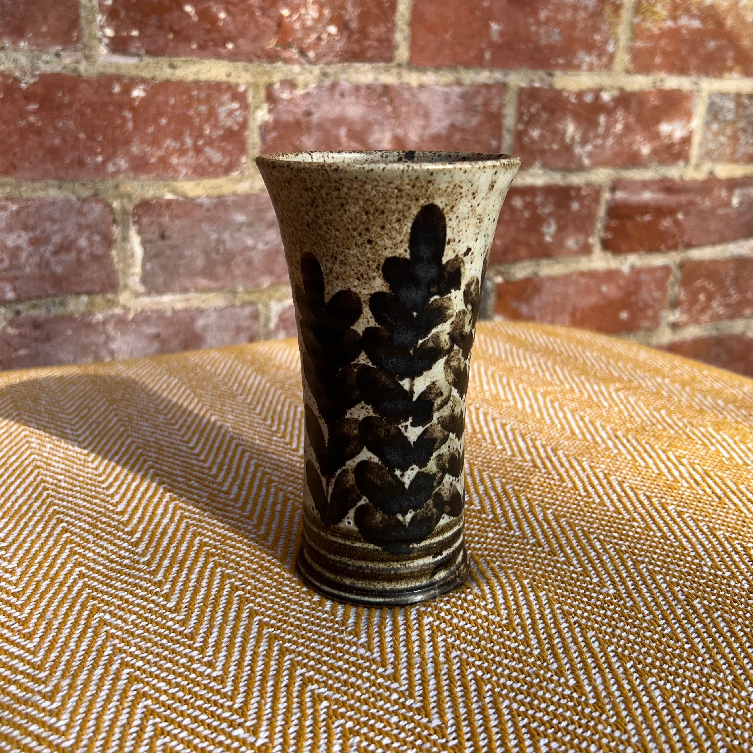 Floral ceramic vase with speckled beige and dark brown glaze and black abstract leaf pattern