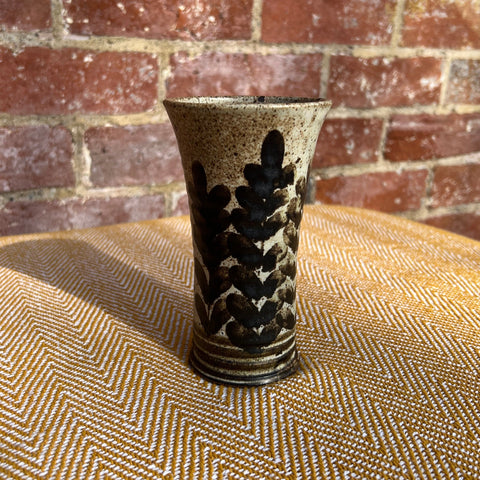 Floral ceramic vase with speckled beige and dark brown glaze and black abstract leaf pattern