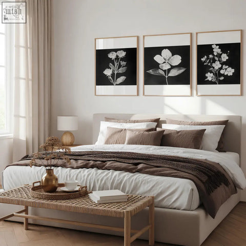 Beige upholstered bed with layered white and brown bedding paired with charcoal and white floral wall art set of 3