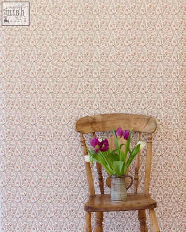 A rustic wooden chair with a vintage metal pitcher of purple and white tulips in front of florence wallpaper shell small repeat