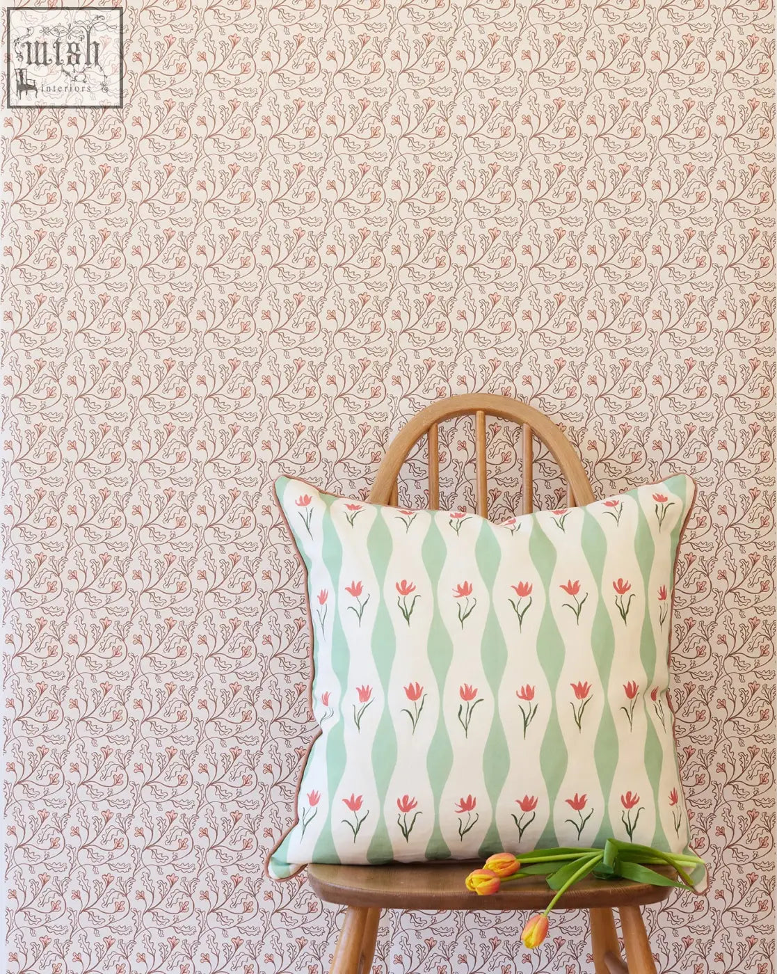 A square cushion with small repeat red tulips and mint green wavy stripes on a white base from florence wallpaper shell