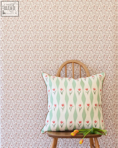 A square cushion with small repeat red tulips and mint green wavy stripes on a white base from florence wallpaper shell