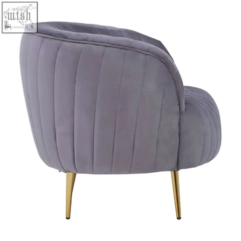 A plush florina grey velvet chair with vertical stitching and slender gold legs perfect for stylish seating