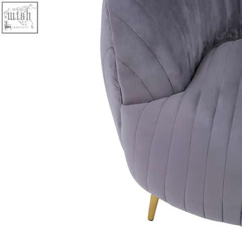 A plush florina grey velvet chair with vertical pleats and slender gold legs perfect for stylish living spaces