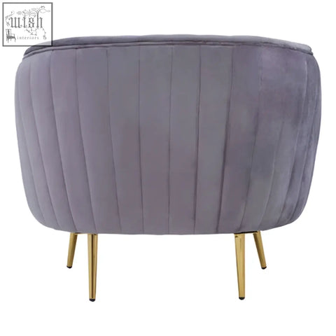 A plush florina grey velvet chair with vertical pleats and slender gold legs perfect for stylish seating