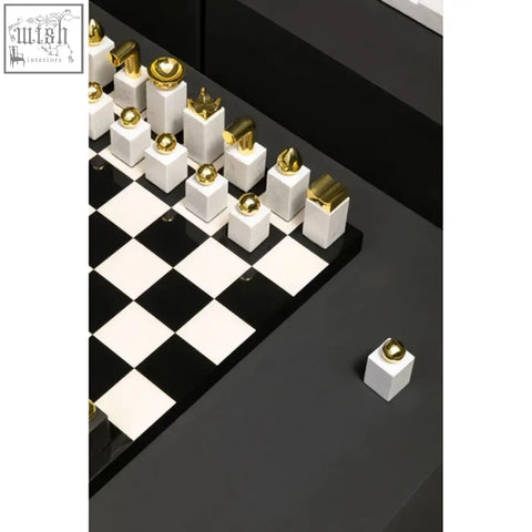 Flos marble and wood chess set with black and white pieces featuring gold accents on a glossy wood chess board