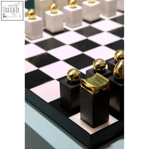 Flos marble and wood chess set with black and white wood chess pieces topped with gold accents