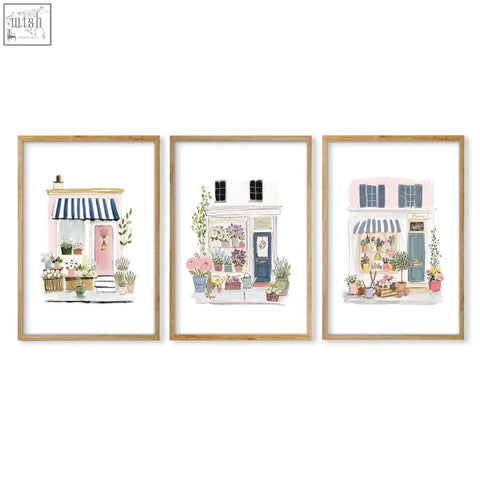 Set of 3 framed flower art prints featuring pastel flower shop facades with striped awnings and potted plants