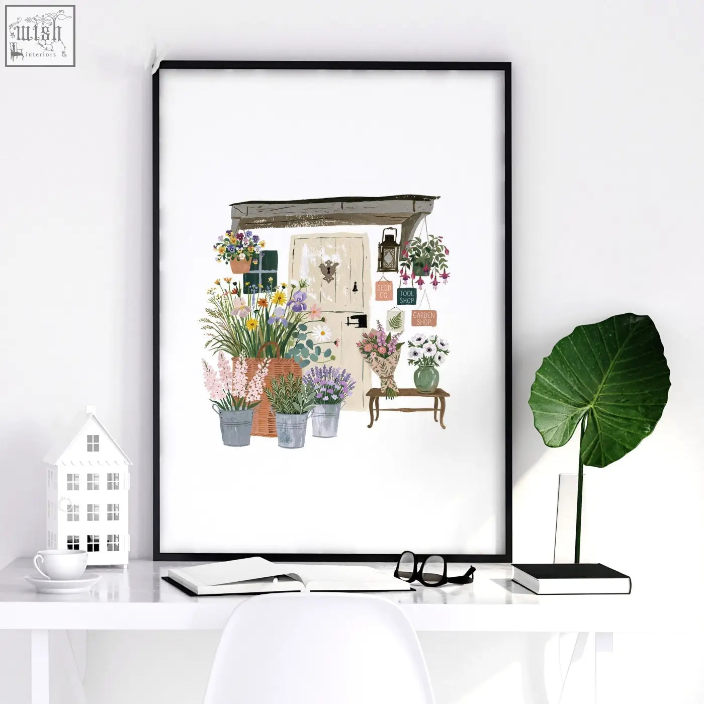 Black-framed flower print wall art showing a charming flower shop scene with vibrant blooms in pots and baskets