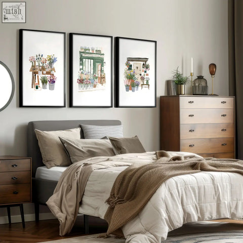 Three framed flower print wall art featuring watercolor flower shop scenes in black frames above the bed