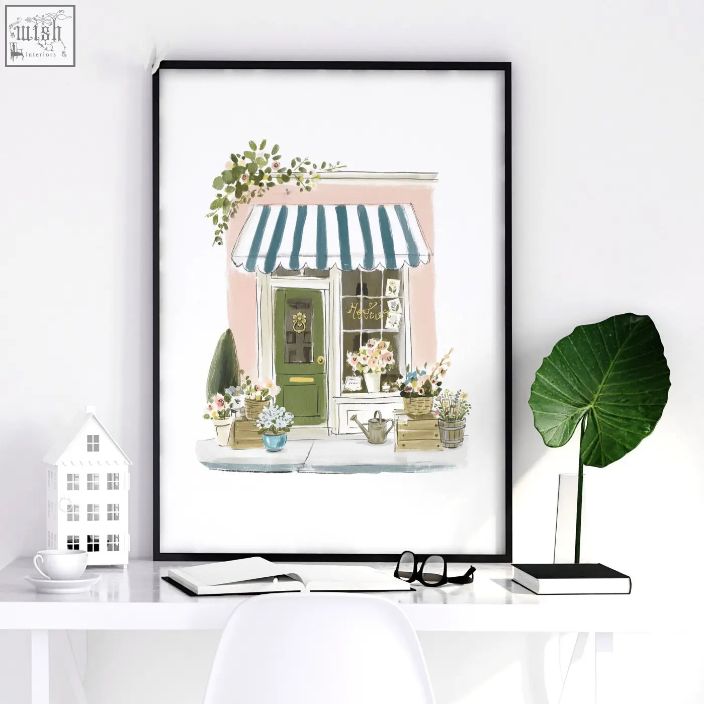 A framed watercolor flower print of a country cottage flower shop with teal striped awning and pink facade wall art