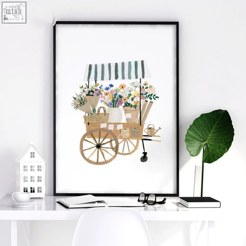 A framed country cottage flower prints set featuring a floral market cart with wooden wheels and colorful flowers