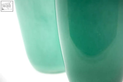 A smooth translucent teal ceramic mug with a glossy finish from the dutz collection mouth blown glass design