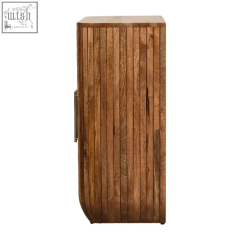 A tall slender mango wood fluted curve chest of drawers with vertical slats and visible grain patterns