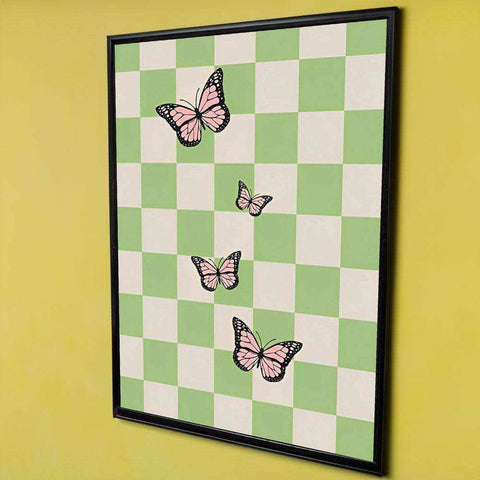 A fluttering freedom print of four pink butterflies with black outlines on a green and white checkered background in a black frame