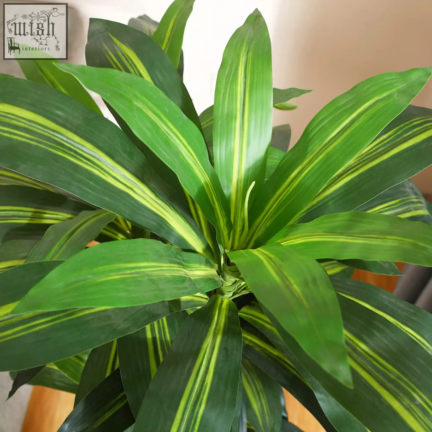 A vibrant green artificial dracaena tree with yellow-striped broad leaves in a decorative indoor pot for home or office