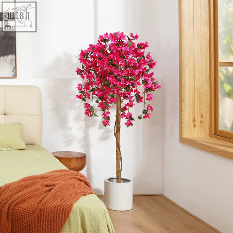 A vibrant pink artificial blossom tree with cascading blooms in a sleek white pot perfect for home decor
