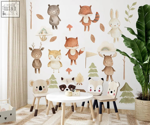 Wooden children’s table with white top and black legs in a forest animals nursery featuring peel and stick wall decals
