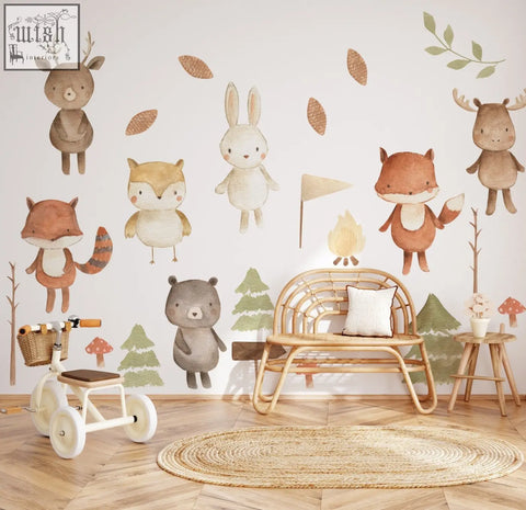 A charming white children’s tricycle with wooden handlebars and woven basket beside forest animals nursery wall decal