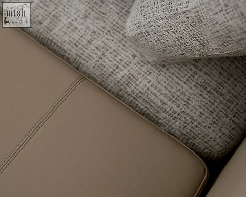 Beige leather seat panel with stitching and textured gray fabric cushion on foster four seater corner sofa linen shipping cost info