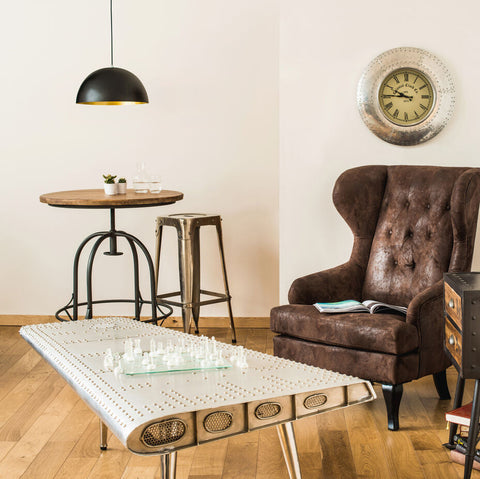 Foundry round top table with sleek metallic riveted surface vintage design and rounded edges for stylish living rooms