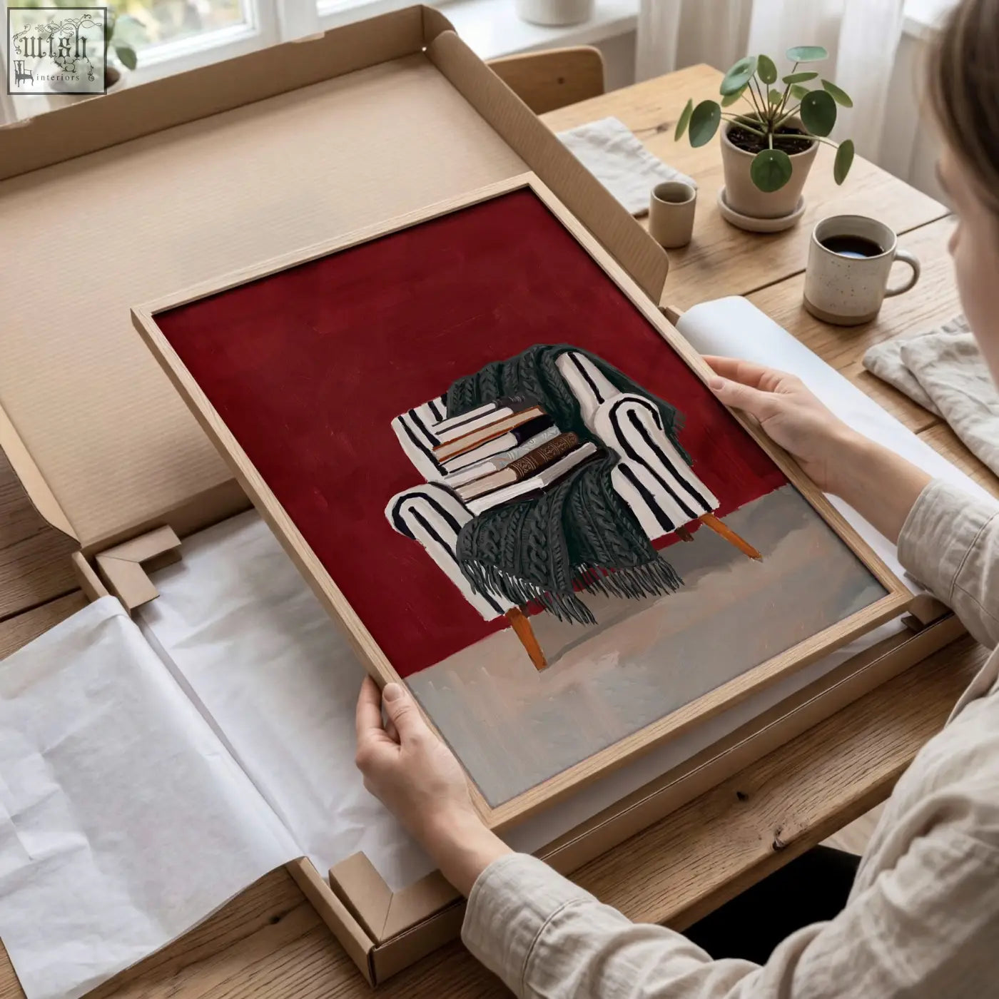 A framed artwork of a striped armchair with a dark green blanket on a burgundy wall for living room reading nook