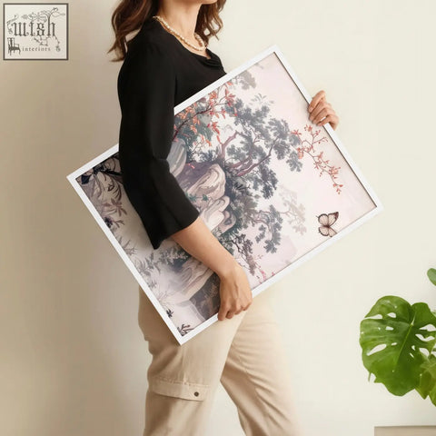 A framed artwork featuring delicate chinoiserie wall art with blossoming branches and butterflies on soft pink paper