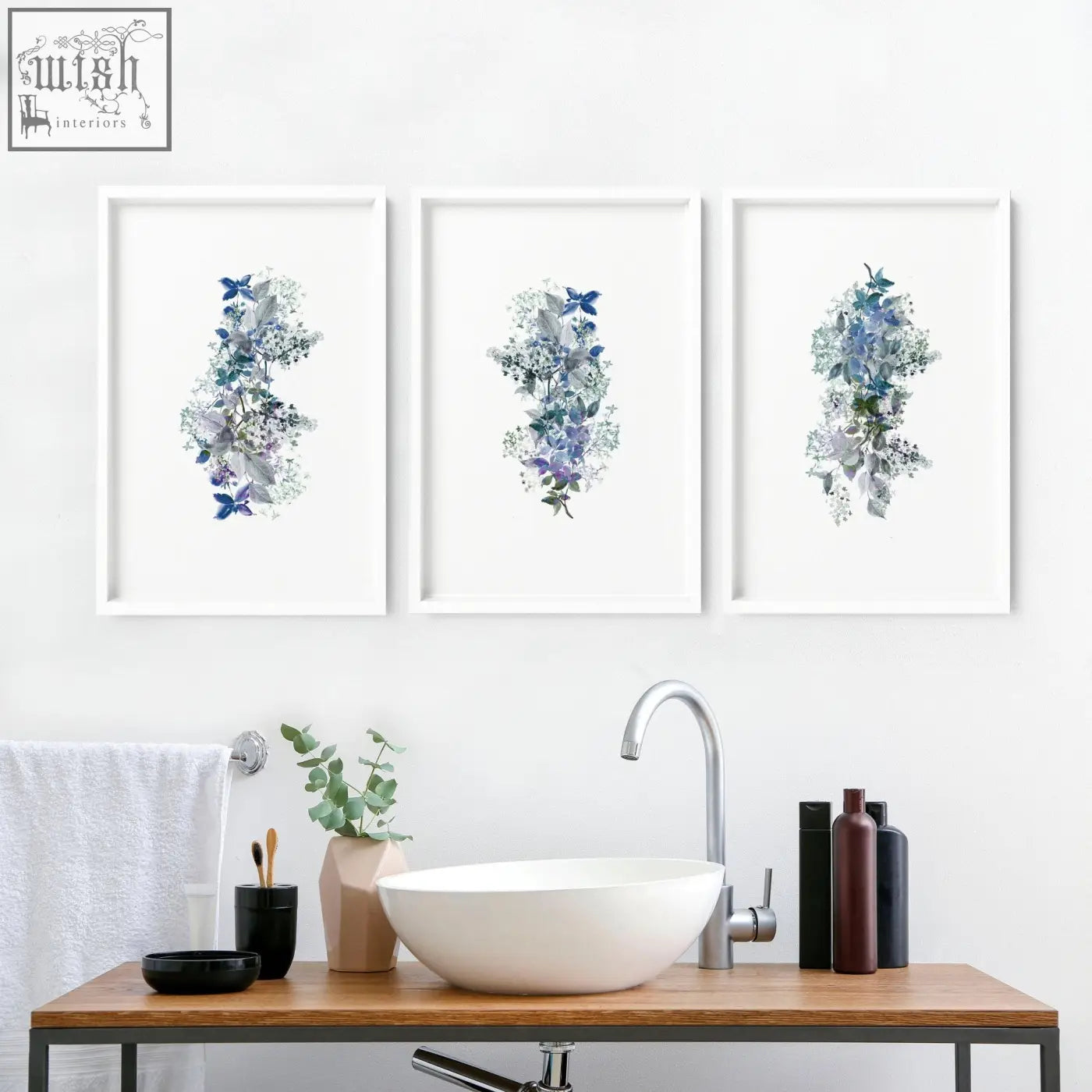 Three shabby chic framed pictures with blue and gray floral watercolor wall prints above a bathroom sink