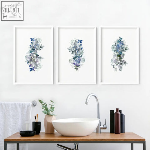 Three shabby chic framed pictures with blue and gray floral watercolor wall prints above a bathroom sink
