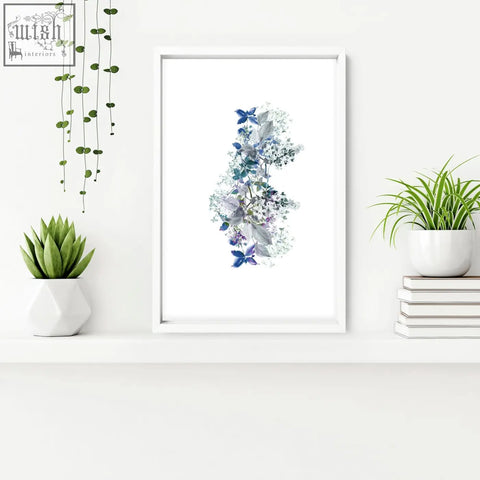 A framed shabby chic wall print featuring delicate blue and purple flowers with butterflies in a white frame