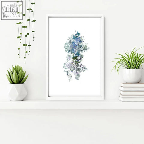 A set of 3 shabby chic framed pictures featuring blue and green floral wall prints in simple white frames for bathroom decor