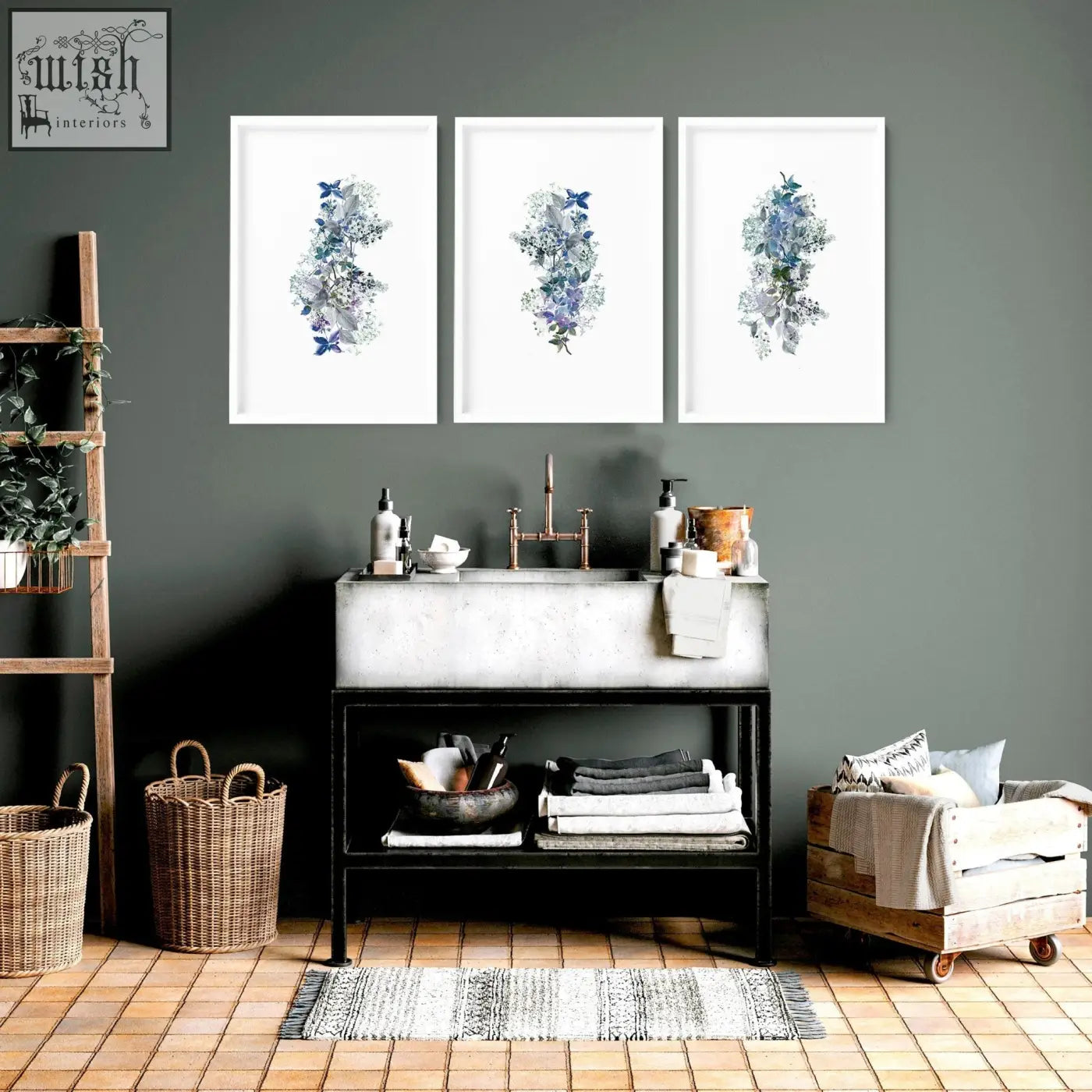 Three shabby chic framed pictures with blue and gray floral wall prints hang above a concrete bathroom sink