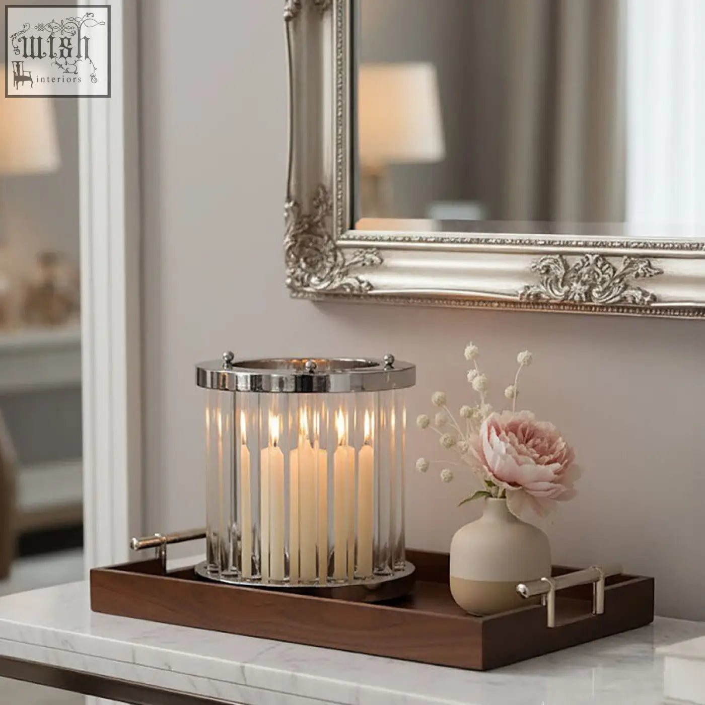A small silver and glass candle holder with a polished chrome frame holding multiple lit glass candles