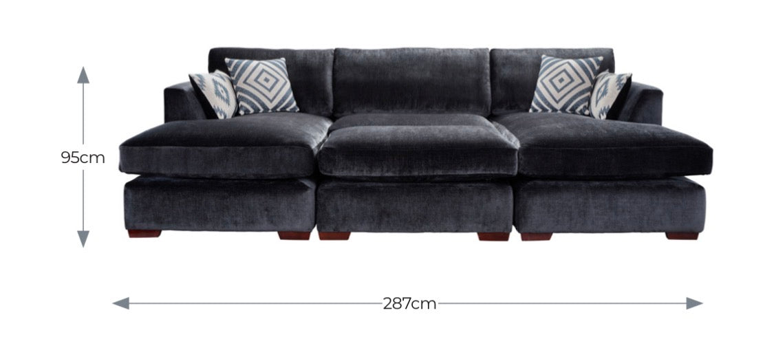 Black velvet freedom sofa double chaise with geometric throw pillows and matching stool for cozy lounging