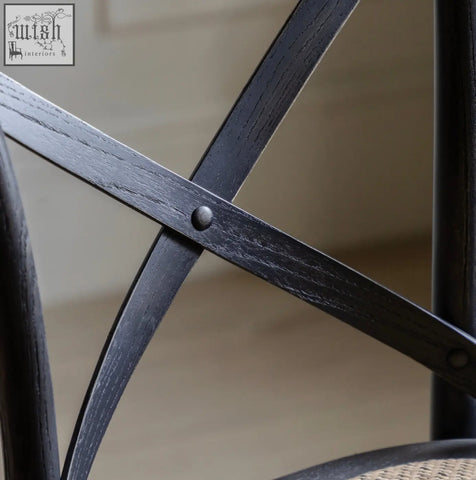 Back of black stained wooden french bistro bar stool with cross frame and visible grain in set of 2 solid rattan frames