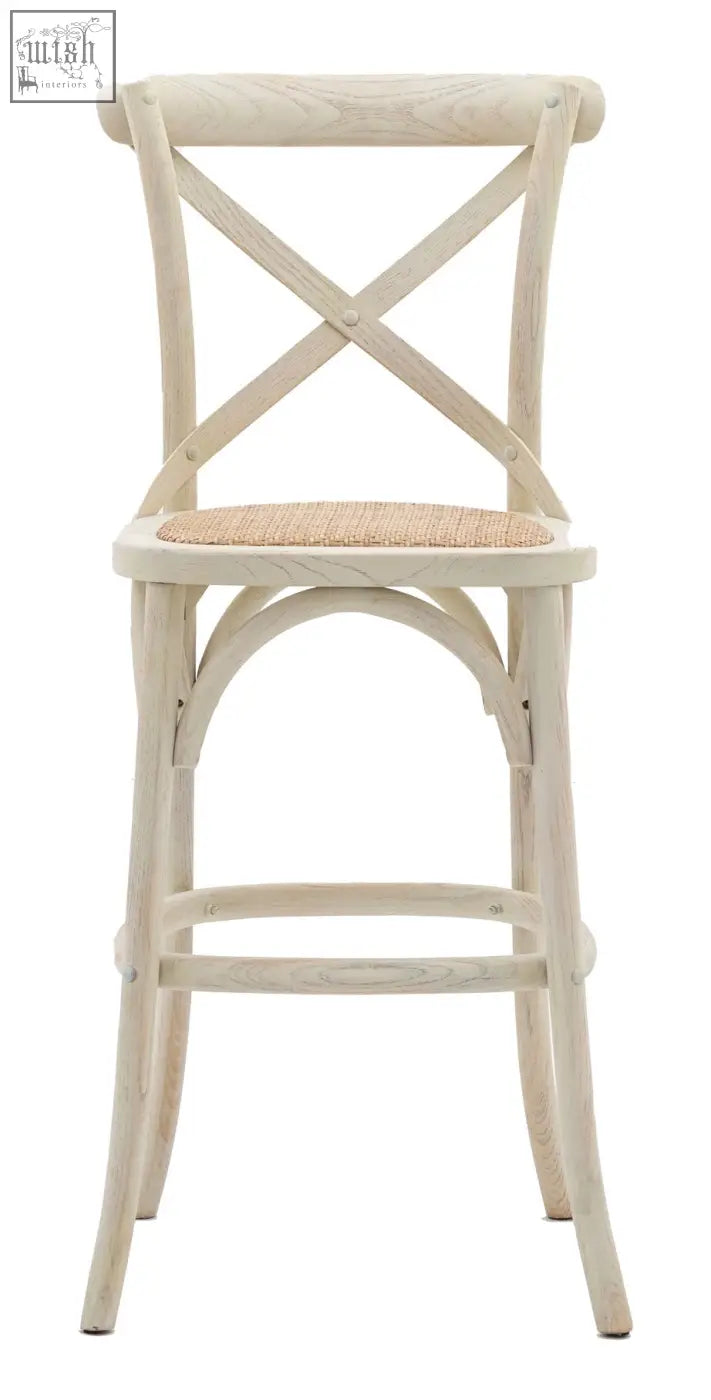 A light cream french bistro bar stool with hand woven rattan cane seat and solid rattan frames x shaped backrest