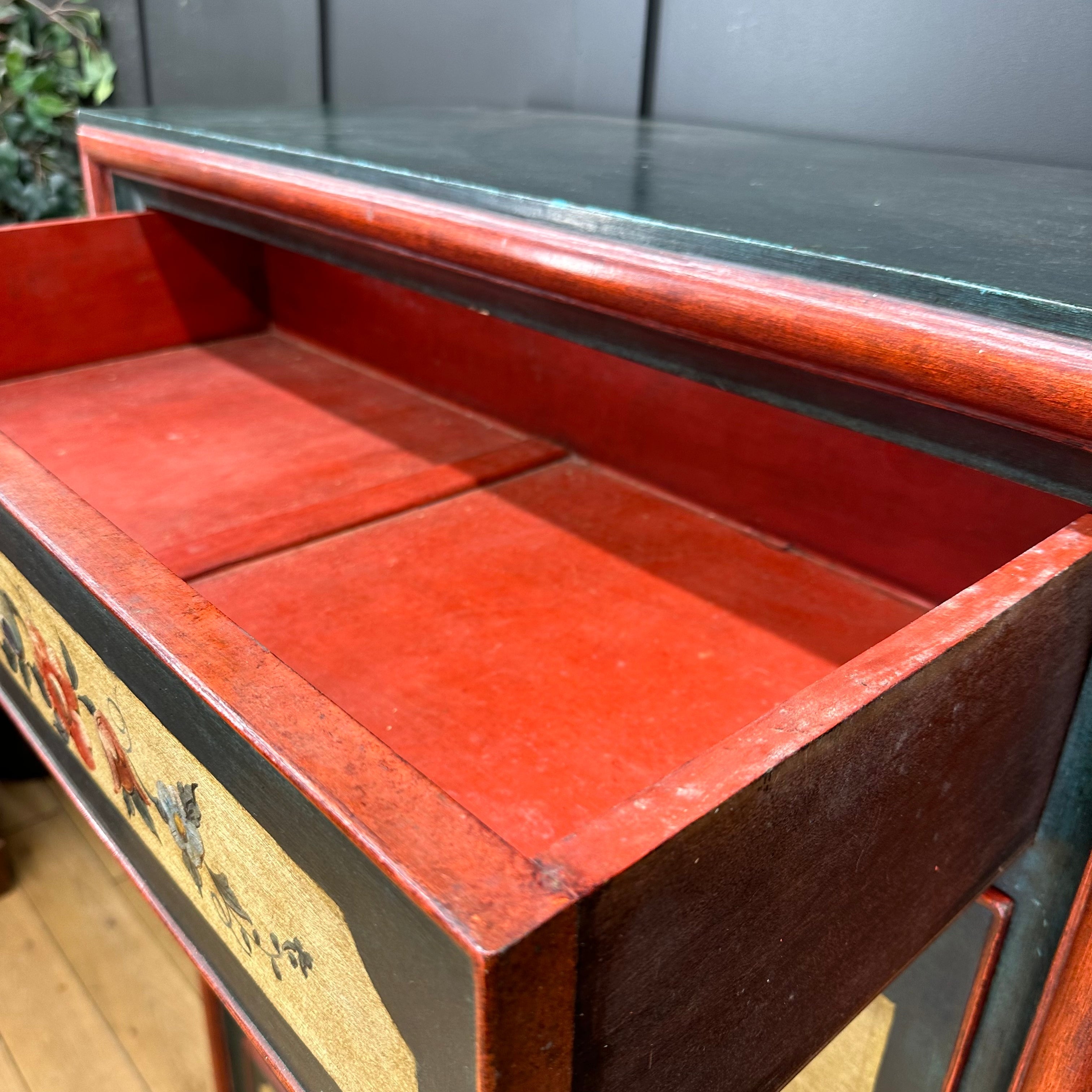 Red lacquered wooden side table with glass top and painted panels used as a french painted drop front secretaire d’abattant