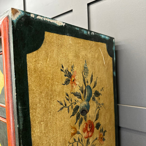 Antique-style framed painting with gilded background and worn green border on a vintage secretaire d’abattant desk