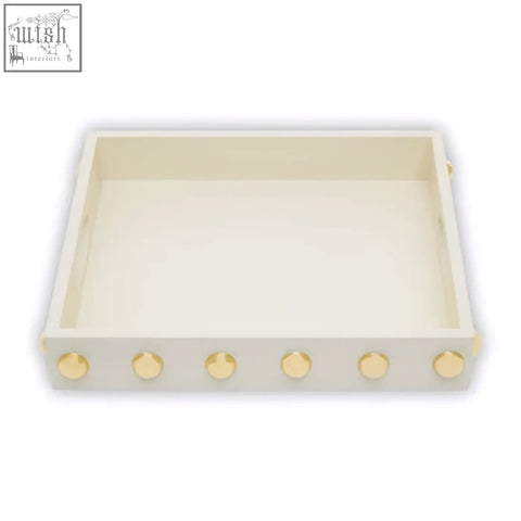 Cream-colored rectangular gold studded tray with gold-toned studs along the front edge for stylish decor