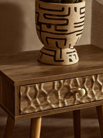 Beige ceramic planter with black maze patterns on a frida wood veneer bedside table with 1 drawer