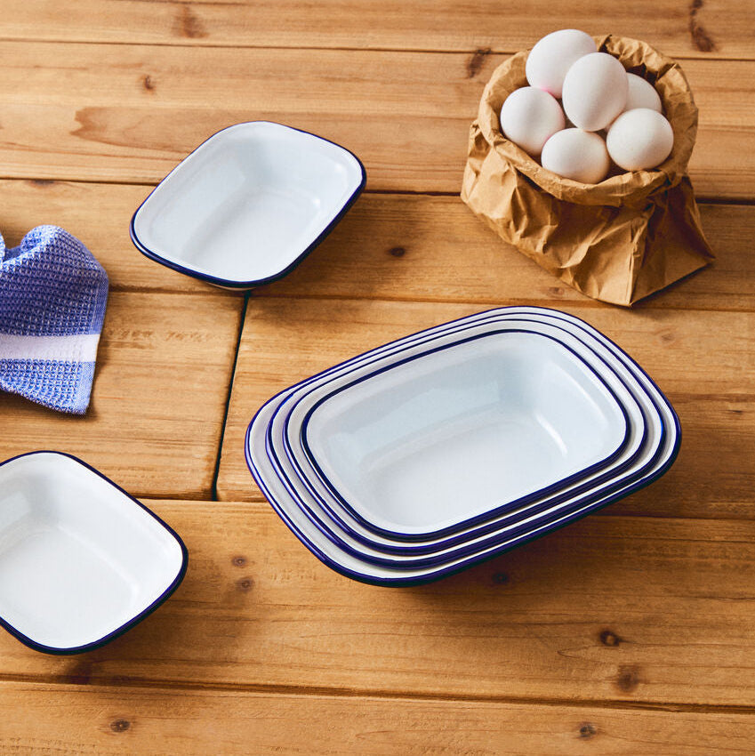 Stacked white enamel rectangular pie dishes with navy blue rims perfect for baking rectangular pies