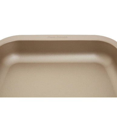 Beige stainless steel undermount kitchen sink with rounded basin and subtle engraving next to from scratch 32cm roasting pan