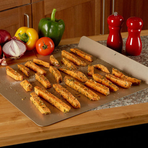 A metallic rectangular from scratch baking sheet with a non-stick surface holding seasoned sweet potato fries
