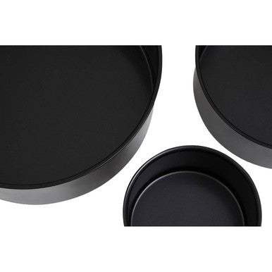 Set of three black non-stick round cake tins with smooth glossy surfaces and slightly raised rims for baking round cakes