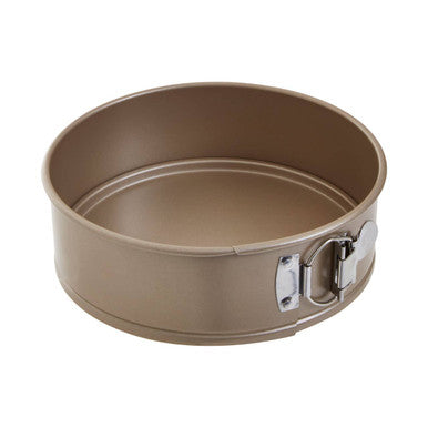 Beige non-stick from scratch small cake pan with silver metal clamps and hinges for easy cake release