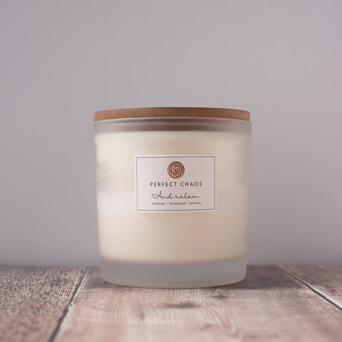A creamy white frosted glass candle with bamboo lid perfect chaos scent blend offers long hours burn time