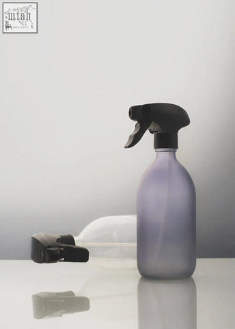 A frosted grey spray bottle with a translucent lavender body and black trigger pump for easy spraying